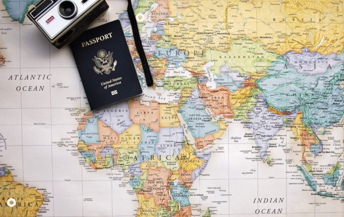 Trasferirsi all'estero-cartina geogarafica-passaporto-macchina fotografica
